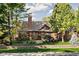 Charming brick home with mature trees, brick wall and an inviting front yard with manicured lawn at 5946 Guilford Ave, Indianapolis, IN 46220