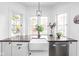 Bright kitchen featuring a farmhouse sink, stainless steel dishwasher, and decorative stained glass windows at 5946 Guilford Ave, Indianapolis, IN 46220