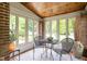 Cozy sun room featuring a wooden ceiling, brick walls, and views of the surrounding landscape at 5946 Guilford Ave, Indianapolis, IN 46220
