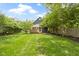 Expansive backyard with lush lawn, deck, and shade trees, creating a serene outdoor space at 6107 Broadway St, Indianapolis, IN 46220