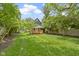 Picturesque backyard showcasing a well-kept lawn, mature trees, and a deck for outdoor enjoyment at 6107 Broadway St, Indianapolis, IN 46220