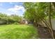 Large grassy backyard featuring a wooden deck and mature trees at 6107 Broadway St, Indianapolis, IN 46220