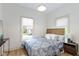 Cozy bedroom with a floral-patterned bedspread, bedside table, and an outside view at 6107 Broadway St, Indianapolis, IN 46220