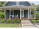 Charming home featuring a cozy front porch with stylish seating and manicured landscaping at 6107 Broadway St, Indianapolis, IN 46220