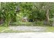 Charming home with fenced yard and a cozy front porch visible through the lush trees at 6107 Broadway St, Indianapolis, IN 46220