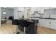 Chic kitchen featuring white cabinetry, a black island with seating, and a modern design at 6107 Broadway St, Indianapolis, IN 46220