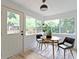 Sunroom features multiple windows, a door to the deck, and a table with seating at 6107 Broadway St, Indianapolis, IN 46220