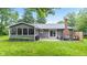 View of the backyard with a cozy screened in porch, patio with seating, brick chimney, and spacious lawn at 6575 E 171St St, Noblesville, IN 46062
