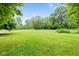 A beautiful green grass backyard with mature trees and landscaping at 6575 E 171St St, Noblesville, IN 46062
