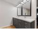 Bathroom with double sink vanity, gray cabinets, white countertop, wood floors and large mirrors at 6575 E 171St St, Noblesville, IN 46062