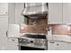 Modern kitchen with stainless steel range and hood, white cabinets, and brick backsplash at 6575 E 171St St, Noblesville, IN 46062