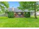 Backyard featuring a lush lawn, mature trees, manicured shrubs, and a wooden deck at 6980 White Oak Dr, Avon, IN 46123
