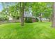 Backyard showcasing lush lawn, mature trees, manicured landscaping, and a wooden deck at 6980 White Oak Dr, Avon, IN 46123