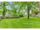 Backyard featuring a lush lawn, mature trees, manicured landscaping, and a wooden fence at 6980 White Oak Dr, Avon, IN 46123