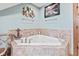 Relaxing corner tub with tile surround, complemented by nautical decor for a serene and inviting ambiance at 6980 White Oak Dr, Avon, IN 46123