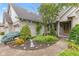 Beautifully landscaped front yard with colorful flowers, mature trees, and a charming brick facade at 6980 White Oak Dr, Avon, IN 46123