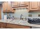 A kitchen sink with granite countertops and wooden cabinets create an elegant and functional space at 6980 White Oak Dr, Avon, IN 46123