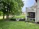 Beautiful backyard featuring a cozy fire pit area, screened in porch and mature trees at 7106 Royal Oakland Dr, Indianapolis, IN 46236