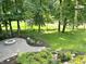 Picturesque backyard with a fire pit, stone patio, and views of the trees and creek at 7106 Royal Oakland Dr, Indianapolis, IN 46236