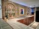 This basement bar area boasts brick backsplash shelving, tile countertops, and plenty of storage at 7106 Royal Oakland Dr, Indianapolis, IN 46236