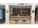 This home's basement features a stylish bar with seating, custom lighting, and framed artwork in view at 7106 Royal Oakland Dr, Indianapolis, IN 46236