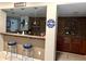 Basement bar features two stools, brick accents, and custom shelving for bottles and glassware at 7106 Royal Oakland Dr, Indianapolis, IN 46236