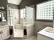 Bathroom featuring a glass block shower, window, and dual vanities at 7106 Royal Oakland Dr, Indianapolis, IN 46236