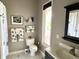 The bathroom features a white toilet, black framed mirror, and natural light from the window at 7106 Royal Oakland Dr, Indianapolis, IN 46236