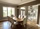 Elegant dining room featuring hardwood floors, large windows, and a classic chandelier at 7106 Royal Oakland Dr, Indianapolis, IN 46236