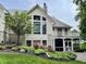 Rear exterior showcasing lush gardens and a balcony, offering a serene retreat at 7106 Royal Oakland Dr, Indianapolis, IN 46236