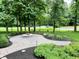 Fire pit area features a stone fire pit, manicured hedges, and mature trees at 7106 Royal Oakland Dr, Indianapolis, IN 46236