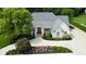 Beautifully landscaped front exterior with a circular driveway and lush, mature trees at 7106 Royal Oakland Dr, Indianapolis, IN 46236