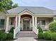 Inviting front porch with classic columns, elegant seating, and manicured landscaping at 7106 Royal Oakland Dr, Indianapolis, IN 46236