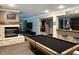Basement game room offers a billiards table, fireplace, bar, and plenty of entertaining space at 7106 Royal Oakland Dr, Indianapolis, IN 46236