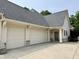 Exterior view showcasing an attached garage with multiple doors and professional landscaping at 7106 Royal Oakland Dr, Indianapolis, IN 46236