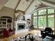 Open living room has a fireplace, built-in shelving, and a large window overlooking the backyard at 7106 Royal Oakland Dr, Indianapolis, IN 46236