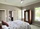 This main bedroom features a ceiling fan, closet, and a view to the home's exterior at 7106 Royal Oakland Dr, Indianapolis, IN 46236