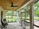 Relaxing screened porch featuring wood ceiling, ceiling fan and outdoor furniture, offering scenic views of the landscaped yard at 7106 Royal Oakland Dr, Indianapolis, IN 46236
