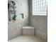 Tiled shower with a built-in seat, glass block window and handheld shower fixture at 7106 Royal Oakland Dr, Indianapolis, IN 46236
