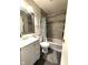 Cozy bathroom featuring gray tiled walls, flamingo rug and modern white vanity at 729 Maple Ln, Brownsburg, IN 46112