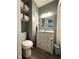 Well-lit bathroom with gray walls, a modern vanity, and functional storage shelves at 729 Maple Ln, Brownsburg, IN 46112