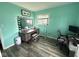 Bedroom featuring a turquoise wall, vanity table, laminate flooring, and natural light at 729 Maple Ln, Brownsburg, IN 46112