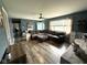 Spacious living room featuring hardwood floors, a plush sectional sofa, and a blue door at 729 Maple Ln, Brownsburg, IN 46112
