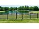 Picturesque lake view from the backyard, complete with a secure fence and lush greenery at 7413 Misty Woods Ln, Indianapolis, IN 46237