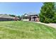 Lush backyard with mature evergreens, open green space and a playground at 7413 Misty Woods Ln, Indianapolis, IN 46237