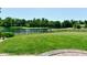 Tranquil backyard with lush lawn and a serene lake view, enclosed by a secure fence at 7413 Misty Woods Ln, Indianapolis, IN 46237
