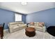 Basement living area featuring reclining sofa set, round wood table, and natural light at 7413 Misty Woods Ln, Indianapolis, IN 46237