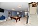 Spacious carpeted basement featuring a pool table, bar area, and access to the upper level at 7413 Misty Woods Ln, Indianapolis, IN 46237