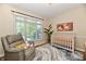 Cozy Bedroom features a comfortable recliner, wooden crib, and stylish rug for a warm and inviting space at 7413 Misty Woods Ln, Indianapolis, IN 46237