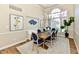 Bright dining room with modern chandelier, white wainscoting, and large window at 7413 Misty Woods Ln, Indianapolis, IN 46237